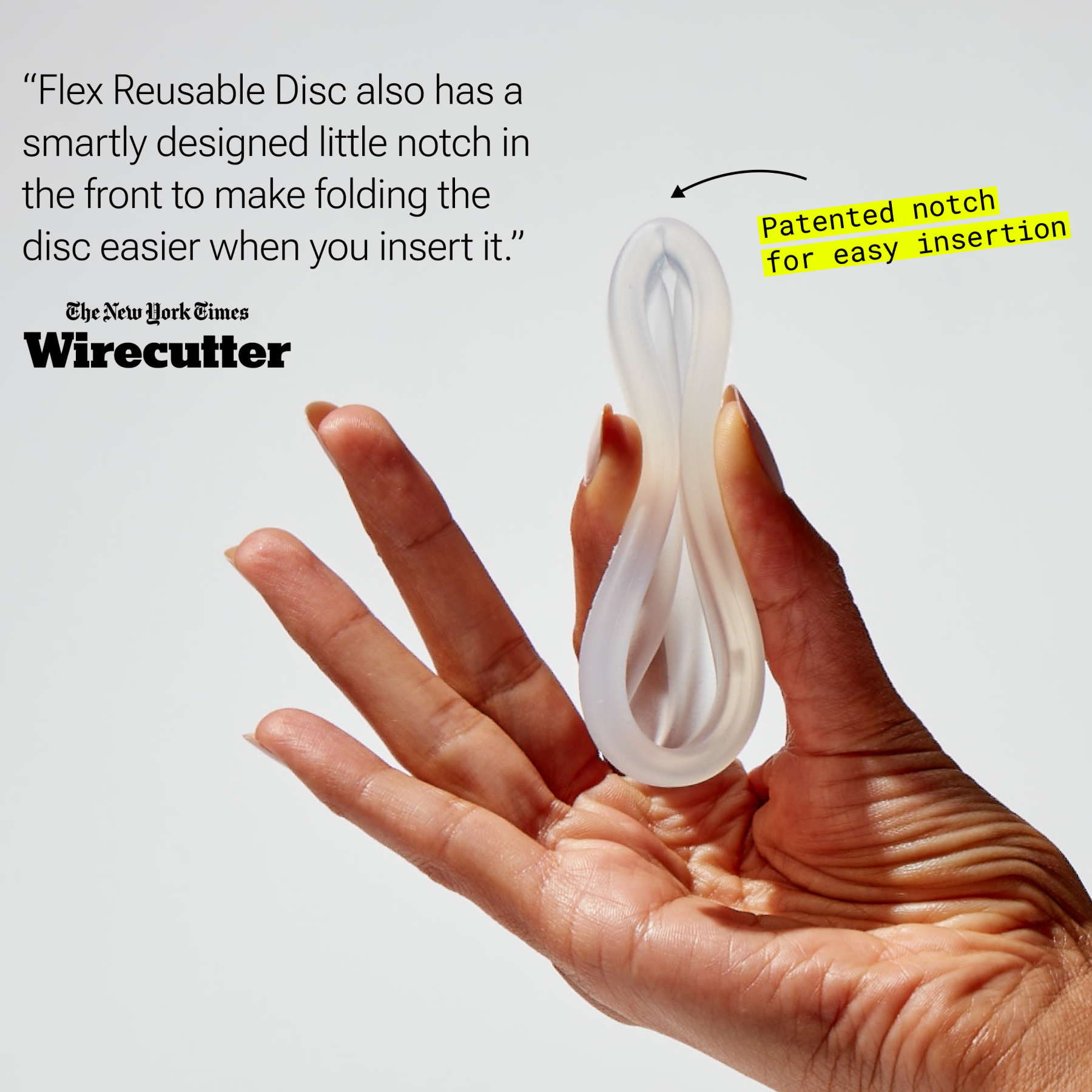 Hand holding folded reusable menstrual disc with visible notch for easier insertion