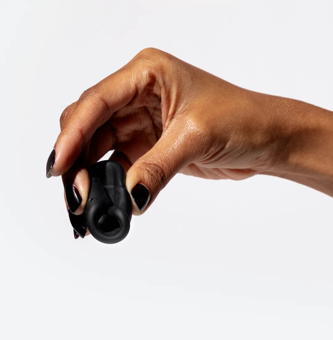 Hand holding a folded menstrual cup to demonstrate compression for insertion