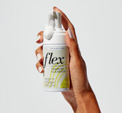 Hand holding pH balanced foaming cleanser with foam dispensed from pump