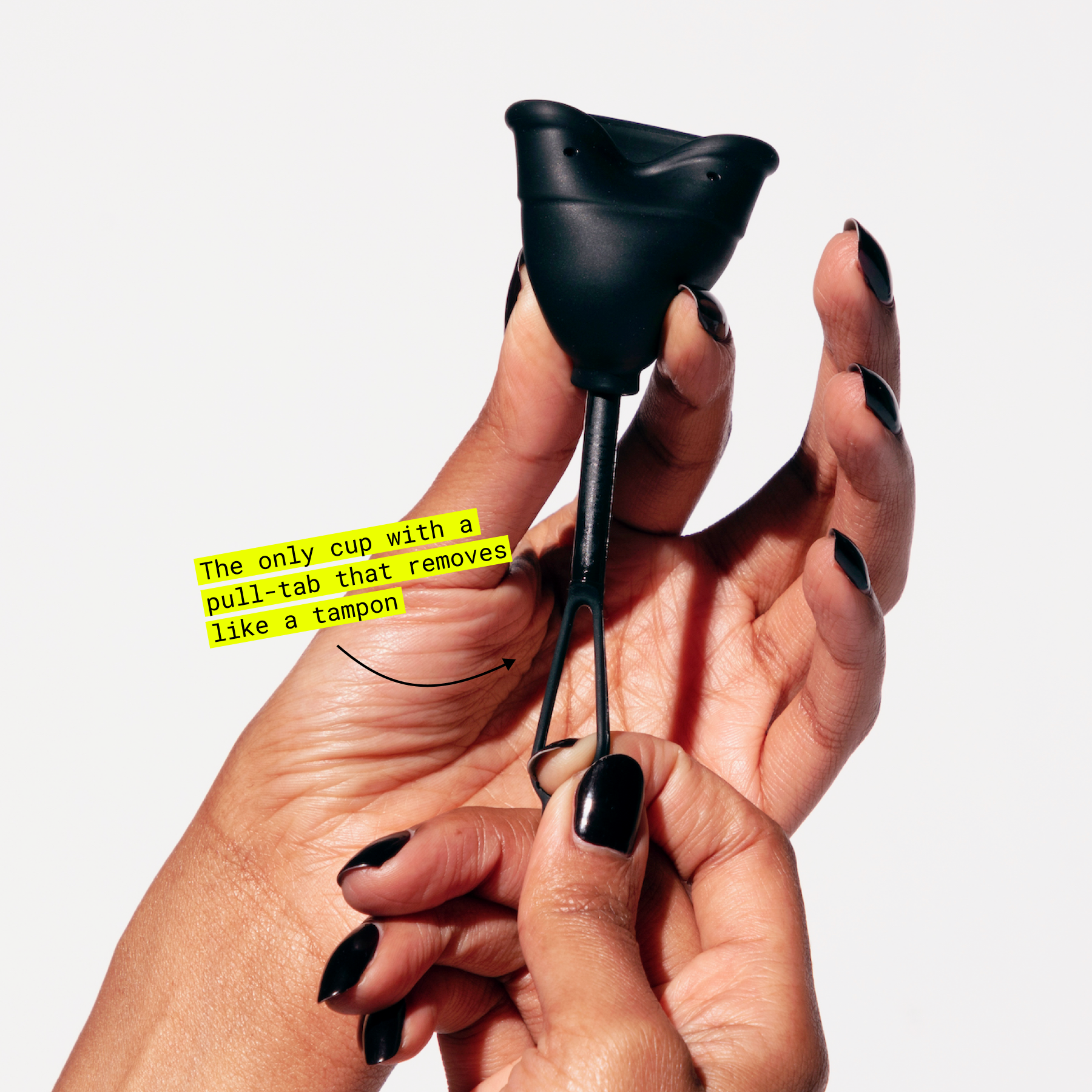 Hand holding a menstrual cup with a pull-tab stem design