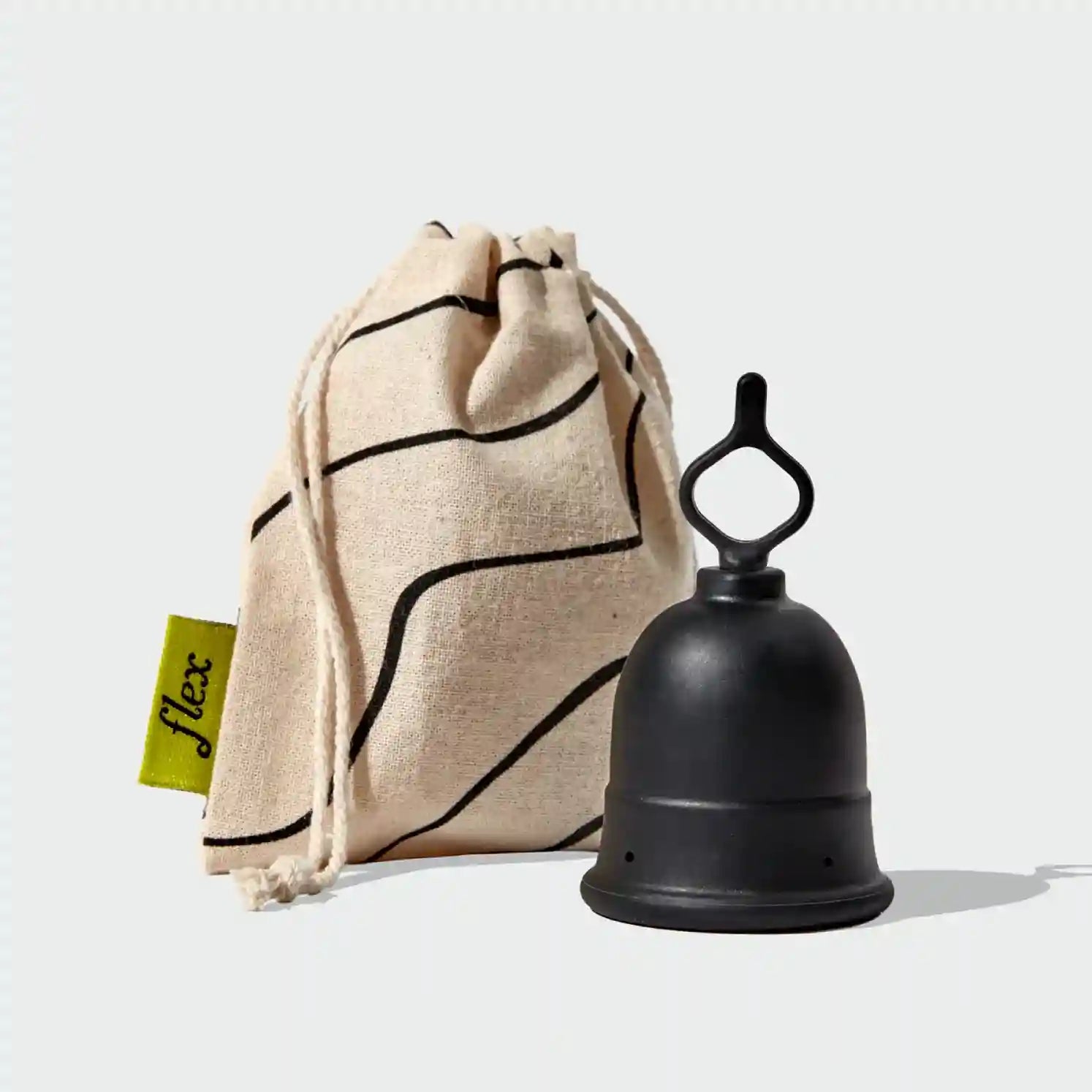 Menstrual cup with loop-style stem next to drawstring storage pouch