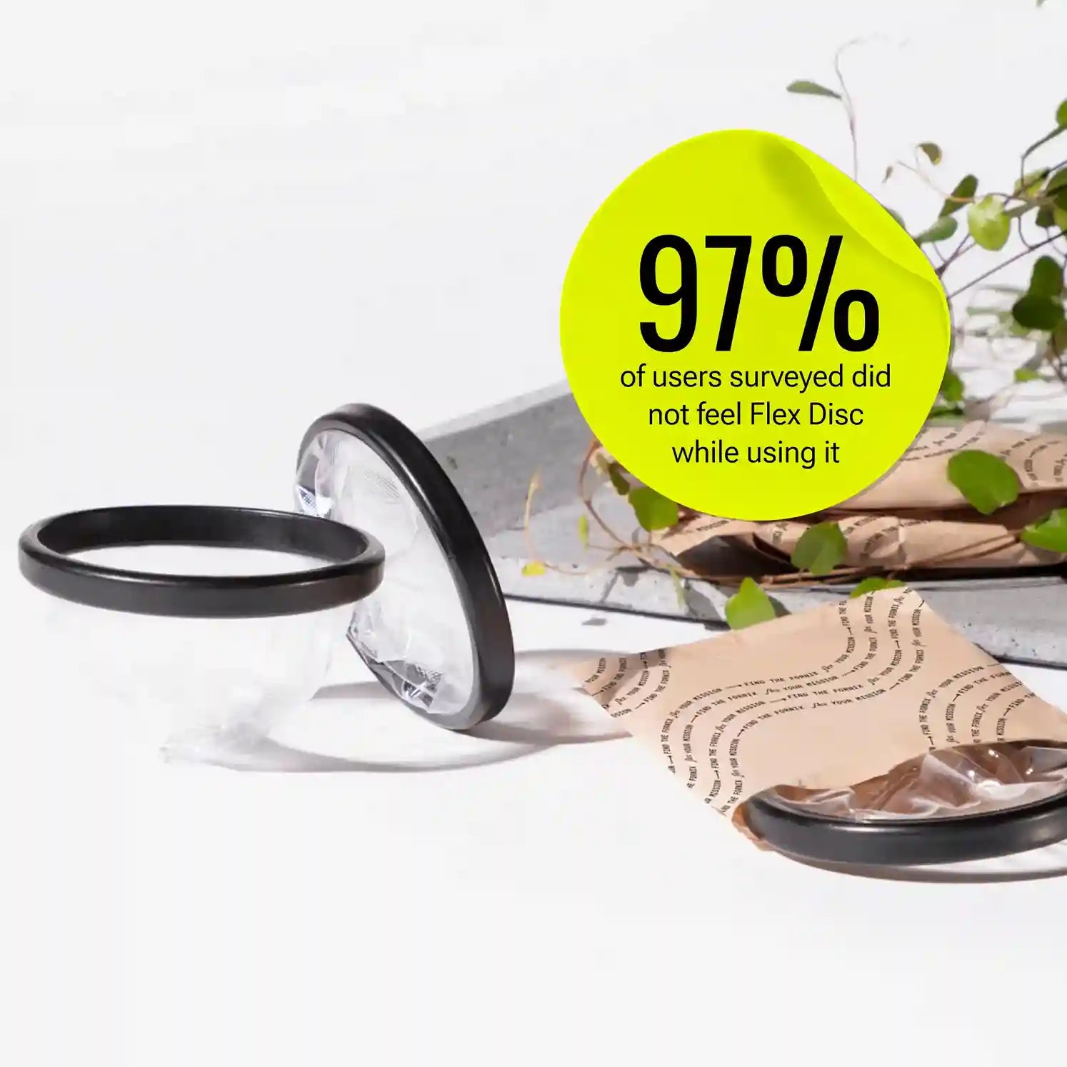 Menstrual discs shown outside packaging with wrapper and plant decor in background